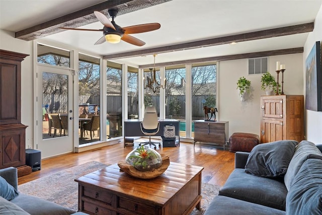 sunroom with beam ceiling, ceiling fan with notable chandelier, and visible vents