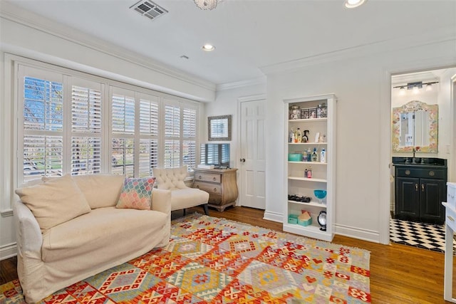 living area with visible vents, ornamental molding, wood finished floors, recessed lighting, and baseboards