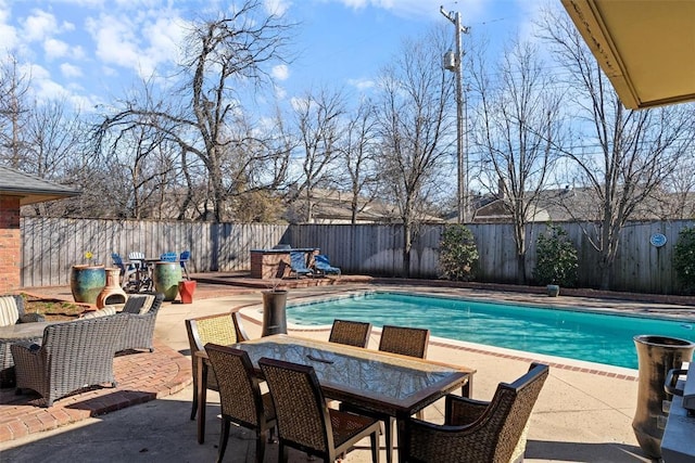 view of pool featuring a patio, outdoor dining area, a fenced backyard, and a fenced in pool