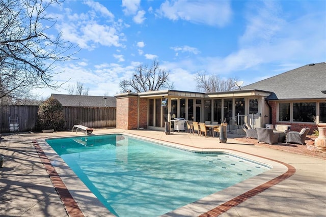 view of pool with a patio, a fenced in pool, a fenced backyard, and a diving board