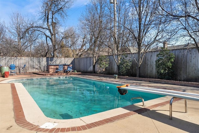 view of swimming pool featuring a patio area, a fenced in pool, a fenced backyard, and a diving board