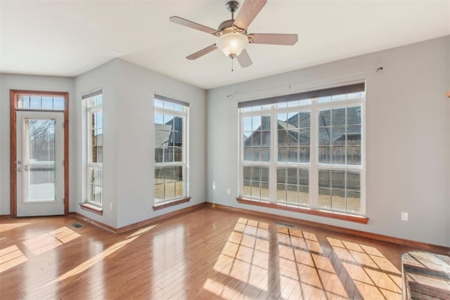 doorway to outside with light wood-style floors, ceiling fan, and baseboards