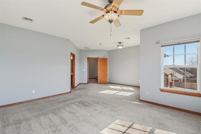 empty room with baseboards, a ceiling fan, visible vents, and light colored carpet