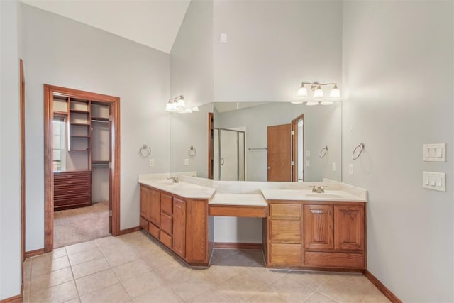 full bathroom featuring a sink, double vanity, a shower stall, and tile patterned floors