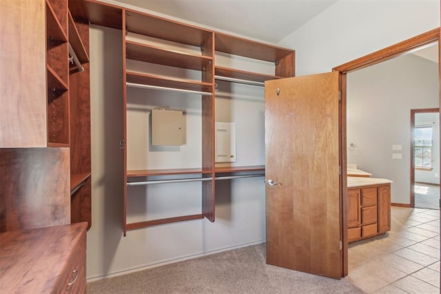 spacious closet with light tile patterned flooring and light colored carpet