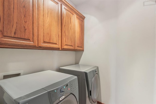 laundry room with washing machine and dryer and cabinet space