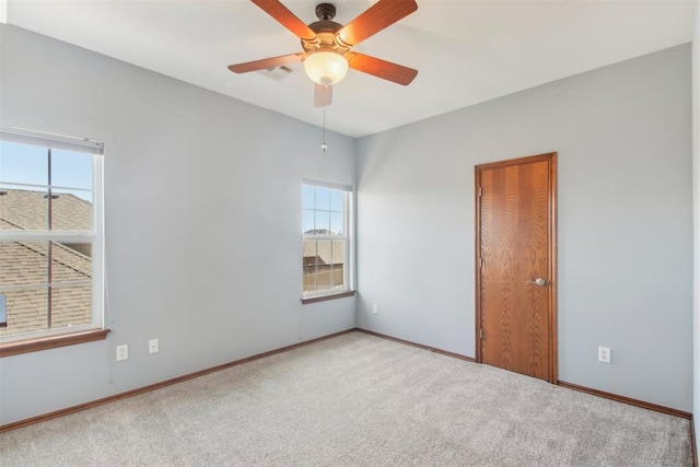 empty room with light carpet, baseboards, and a ceiling fan