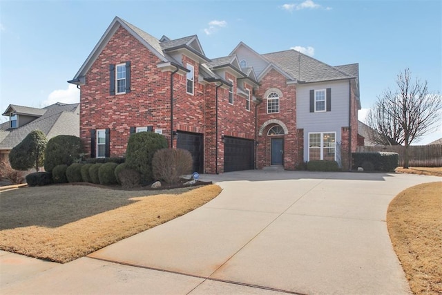 traditional-style house featuring driveway, a garage, brick siding, fence, and a front yard