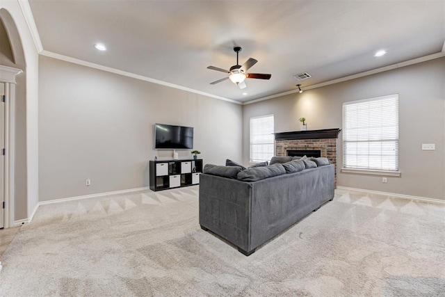 carpeted living room with a brick fireplace, visible vents, crown molding, and baseboards