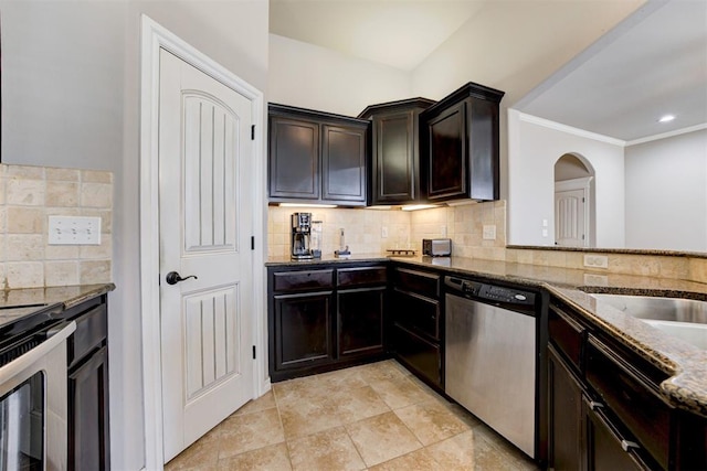 kitchen with stainless steel appliances, tasteful backsplash, ornamental molding, dark brown cabinets, and dark stone counters