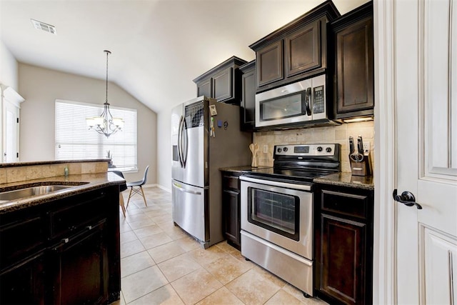 kitchen with light tile patterned floors, stainless steel appliances, visible vents, decorative backsplash, and dark stone countertops