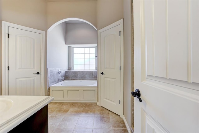 bathroom featuring a garden tub, vanity, and tile patterned floors