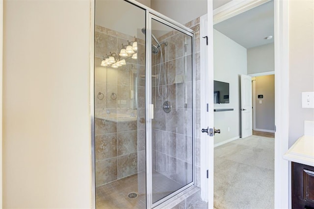 bathroom with a stall shower, vanity, and baseboards