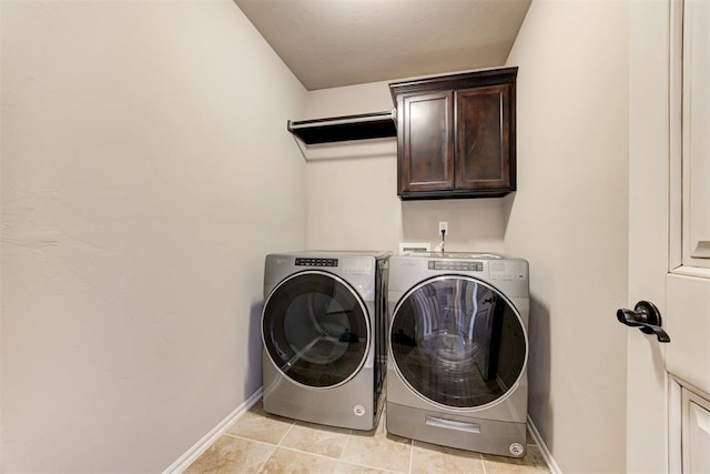 laundry room with light tile patterned flooring, cabinet space, baseboards, and separate washer and dryer