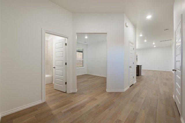 empty room featuring baseboards, recessed lighting, and light wood-style floors