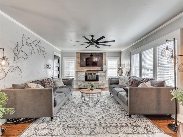 living area with crown molding, wood finished floors, and a healthy amount of sunlight