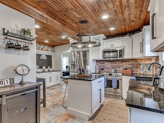 kitchen with arched walkways, wooden ceiling, stainless steel appliances, and a sink