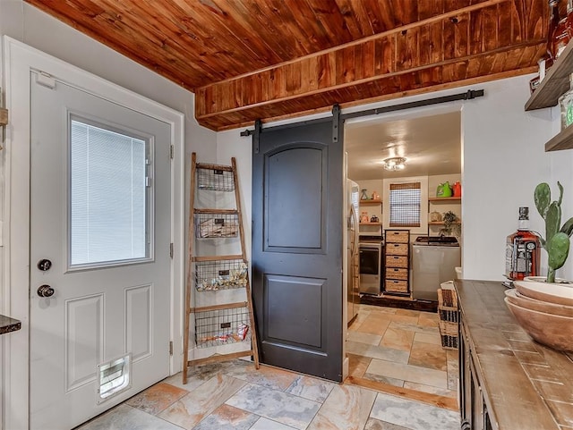 kitchen with stone tile flooring, a barn door, range, and wooden ceiling