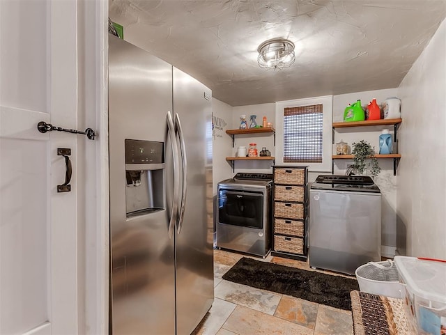 kitchen with open shelves, range, stainless steel fridge, and washer and clothes dryer