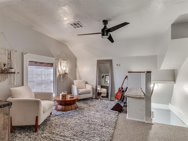 interior space with visible vents, ceiling fan, carpet, and vaulted ceiling