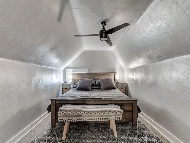 carpeted bedroom with a textured wall, a ceiling fan, baseboards, and vaulted ceiling