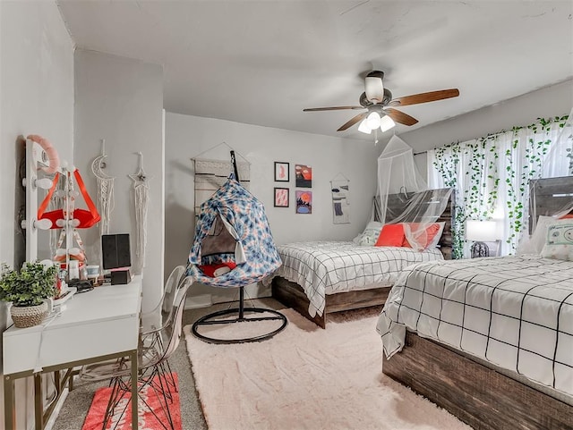 carpeted bedroom with baseboards and ceiling fan