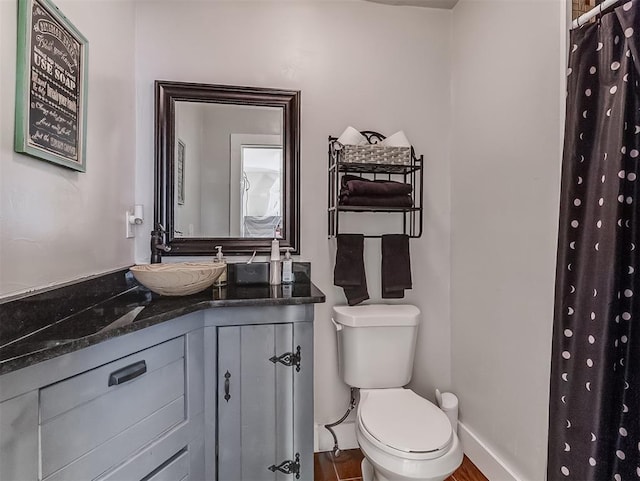 bathroom featuring vanity, curtained shower, toilet, and baseboards