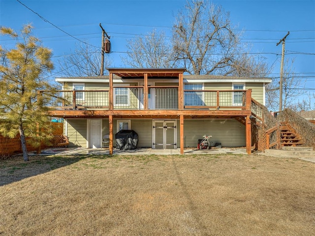 rear view of property with a deck, a patio, stairway, and a yard