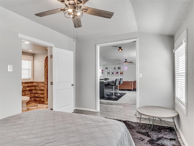 bedroom featuring a ceiling fan, wood finished floors, and connected bathroom