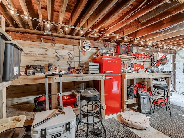 unfinished below grade area featuring wooden walls and a workshop area