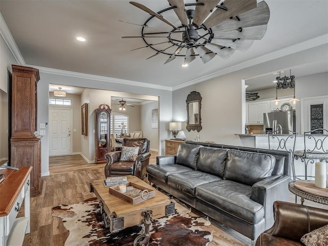 living area with baseboards, a ceiling fan, light wood-style flooring, crown molding, and recessed lighting