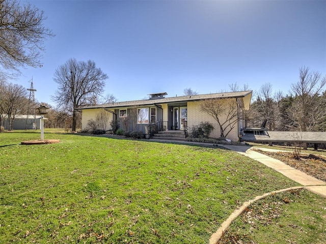 view of front of house featuring a front lawn and brick siding