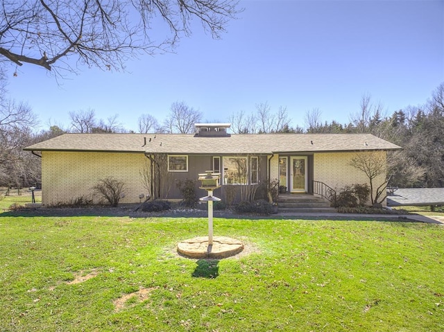 view of front of home with brick siding and a front lawn