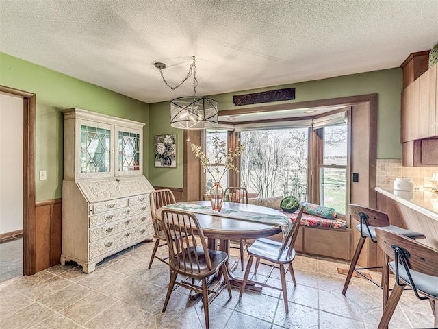 1802 N 15th St, Perry, OK 73077 - dining room with a textured ceiling, a wainscoted wall, and a chandelier