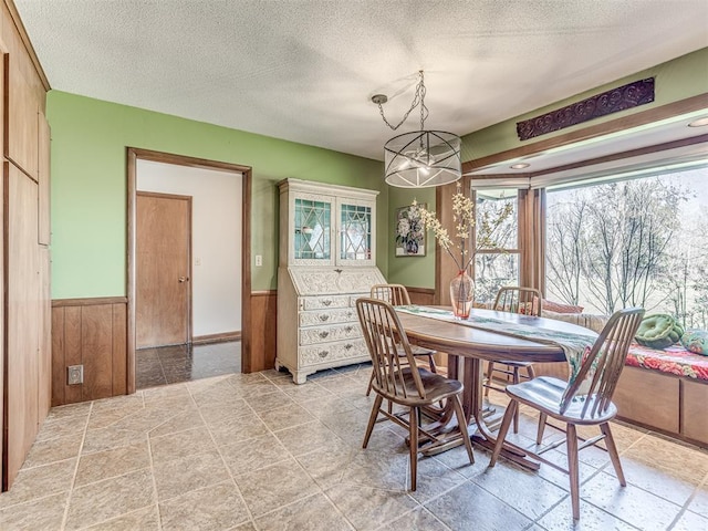 1802 N 15th St, Perry, OK 73077 - dining area with a wainscoted wall, healthy amount of natural light, a textured ceiling, and wood walls