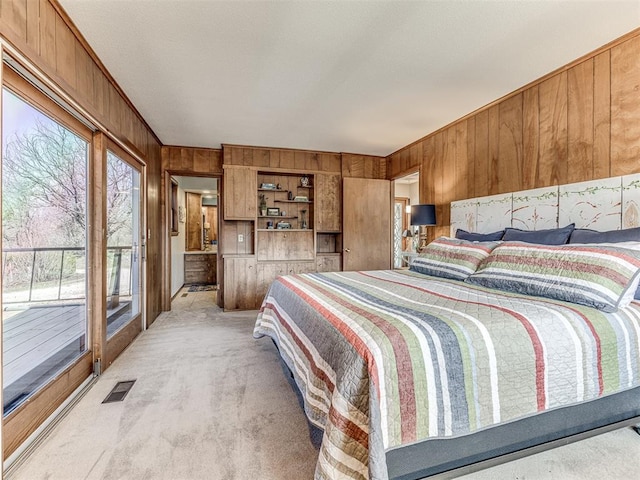 1802 N 15th St, Perry, OK 73077 - bedroom with wooden walls, light colored carpet, and access to outside