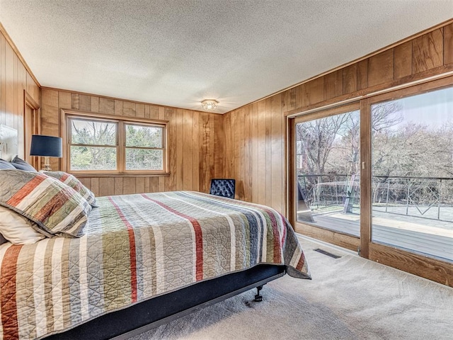 1802 N 15th St, Perry, OK 73077 - bedroom with access to outside, wood walls, carpet floors, and a textured ceiling