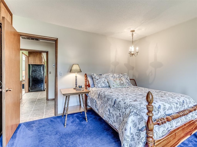1802 N 15th St, Perry, OK 73077 - bedroom with a chandelier, tile patterned flooring, a textured ceiling, and carpet floors