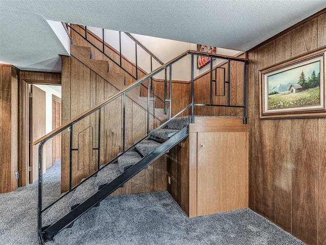 1802 N 15th St, Perry, OK 73077 - staircase with carpet flooring, a textured ceiling, and wooden walls