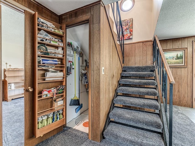1802 N 15th St, Perry, OK 73077 - staircase with wooden walls, carpet, and a textured ceiling