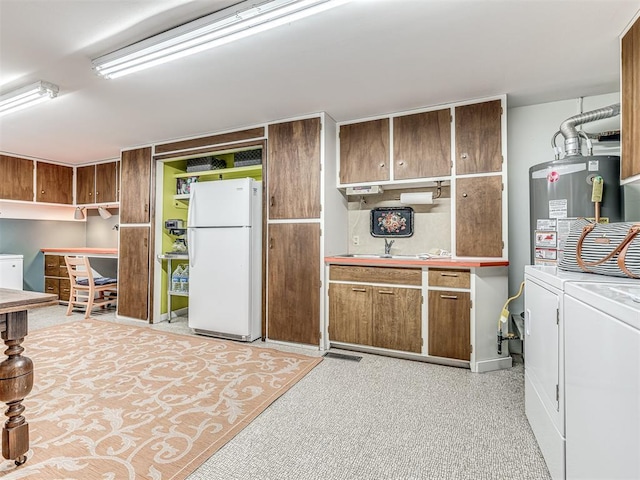 1802 N 15th St, Perry, OK 73077 - kitchen with freestanding refrigerator, independent washer and dryer, water heater, and light countertops