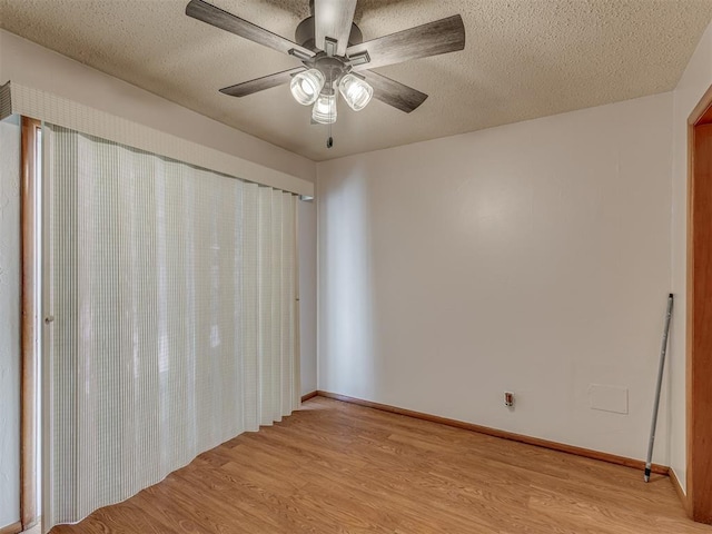 empty room featuring light wood-style floors, ceiling fan, baseboards, and a textured ceiling