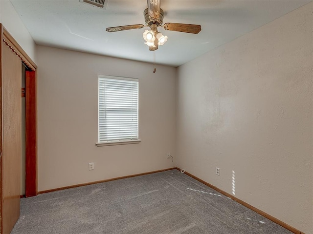 unfurnished room with a ceiling fan, visible vents, baseboards, and carpet flooring