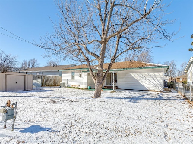 ranch-style home featuring an outbuilding, cooling unit, fence, and a storage unit