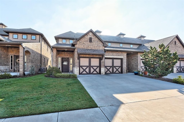 view of front of home with brick siding, central air condition unit, concrete driveway, a garage, and a front lawn