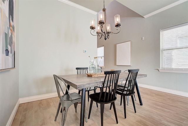 dining space with baseboards, light wood-type flooring, a notable chandelier, and crown molding