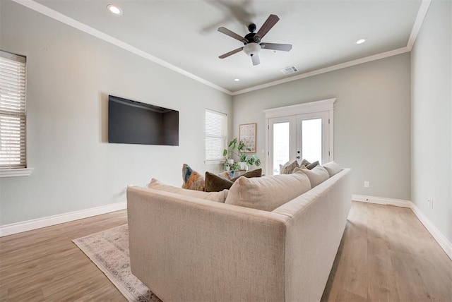 living area with french doors, crown molding, visible vents, light wood-style floors, and baseboards