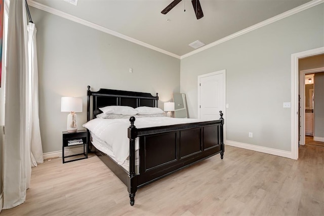 bedroom featuring light wood finished floors, visible vents, baseboards, and crown molding