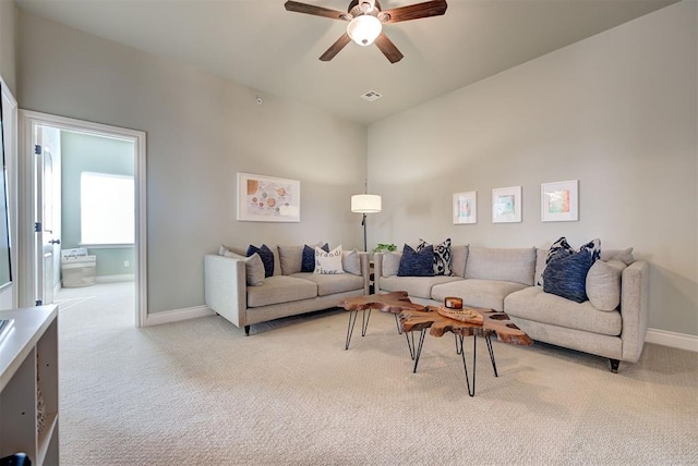 living room with a ceiling fan, light colored carpet, visible vents, and baseboards