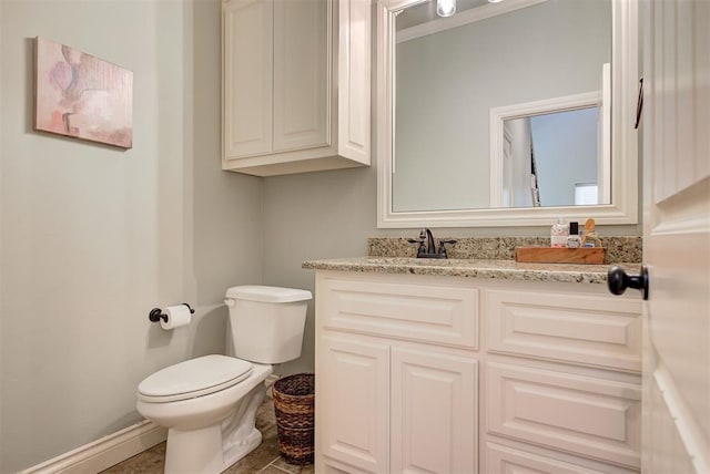 bathroom featuring baseboards, vanity, and toilet